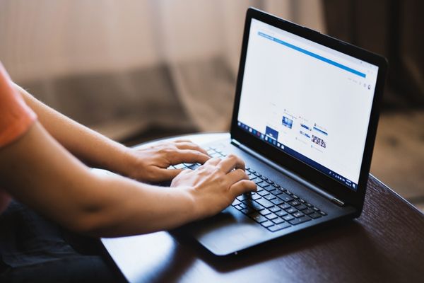 information technology management professional typing on laptop