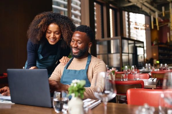 successful entrepreneurs looking at laptop