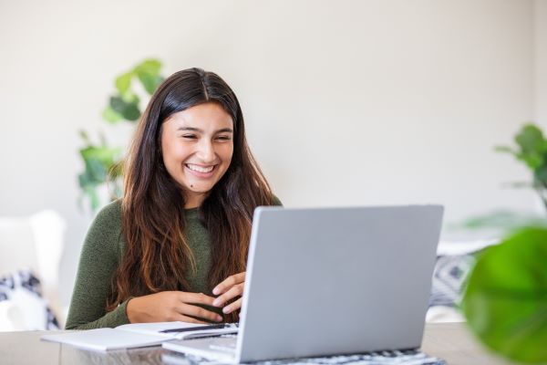 female student communicating virtually on laptop